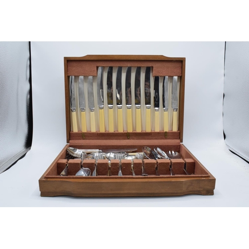 257 - An assorted cutlery canteen with chrome-plated and stainless steel cutlery in a wooden case.