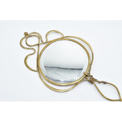 262 - An Art Nouveau brass hand held mirror with a serpent twist towards the top of the handle. 39cm tall.