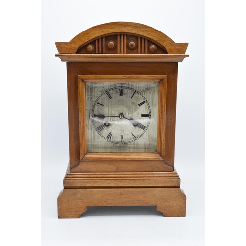 265 - A 20th century wooden cased mantle clock 'J Unghans' with bevel-edged glass and an associated key. A... 