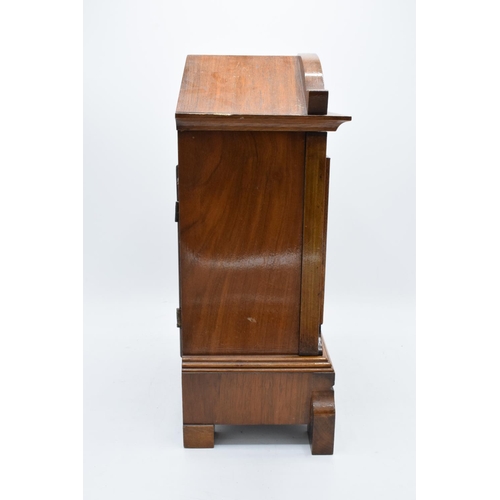 265 - A 20th century wooden cased mantle clock 'J Unghans' with bevel-edged glass and an associated key. A... 