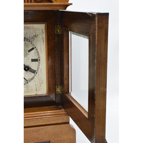 265 - A 20th century wooden cased mantle clock 'J Unghans' with bevel-edged glass and an associated key. A... 