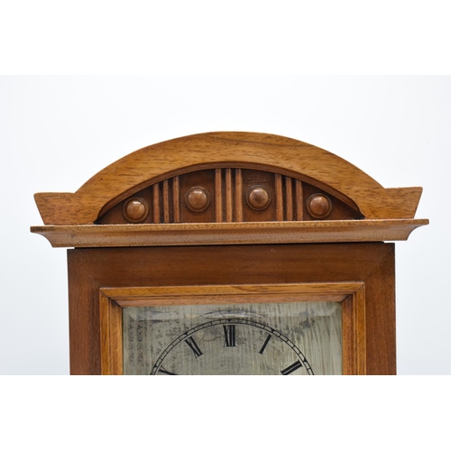 265 - A 20th century wooden cased mantle clock 'J Unghans' with bevel-edged glass and an associated key. A... 