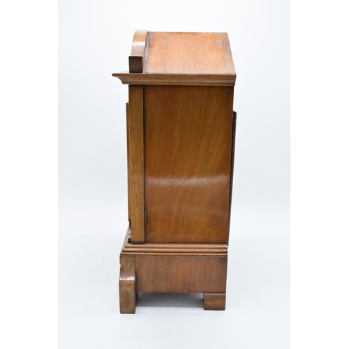 265 - A 20th century wooden cased mantle clock 'J Unghans' with bevel-edged glass and an associated key. A... 