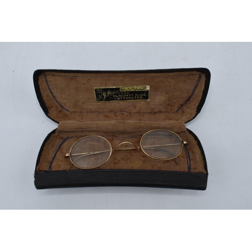 269A - A cased pair of 1/10 10ct gold oval spectacles in original leather carry case by N. J. Rees of 36 Ma... 