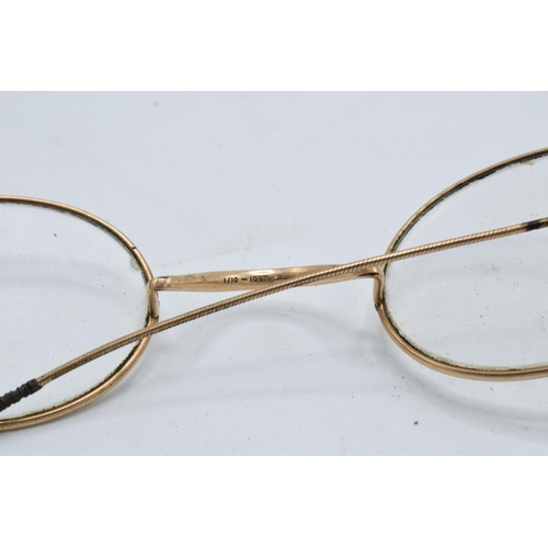 269A - A cased pair of 1/10 10ct gold oval spectacles in original leather carry case by N. J. Rees of 36 Ma... 