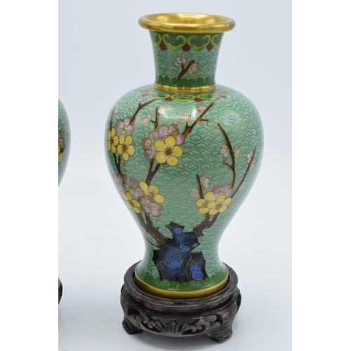 277 - A pair of 20th century cloisonné vases decorated with a green foliage design on wooden bases (2). 22... 