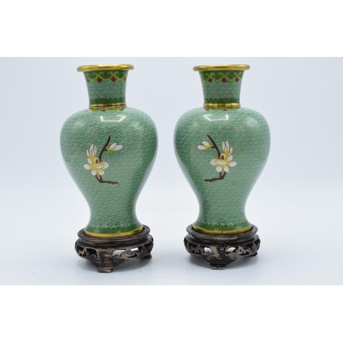 277 - A pair of 20th century cloisonné vases decorated with a green foliage design on wooden bases (2). 22... 