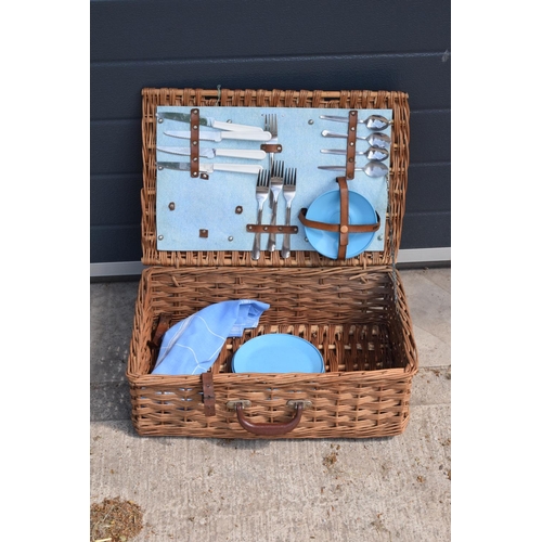 285 - A vintage mid to late 20th century picnic set in a wicker travelling case (part set).