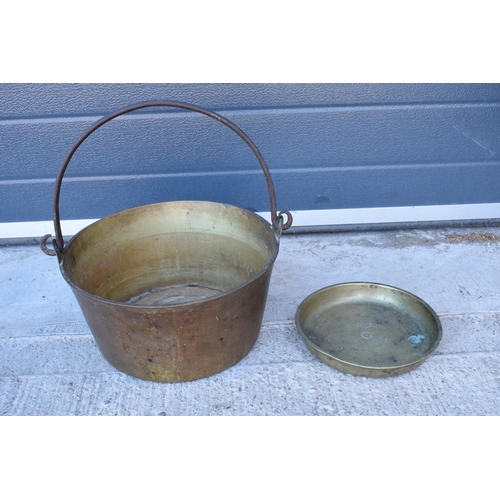 287 - A late 19th/ early 20th century solid brass jam pan together with a brass dish (2). 33cm diameter.