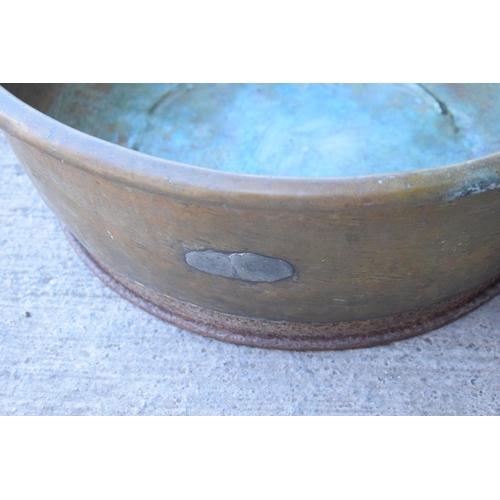 288 - A large oversized antique brass bowl/ basket on a steel base which was used as a log basket/ store. ... 