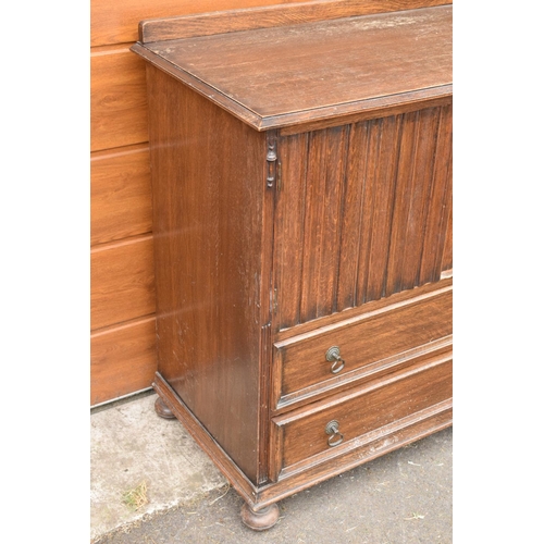 291 - 1930s oak Priory style cupboard over 2 draws raised on feet. 99 x 54 x 103.In good functional condit... 