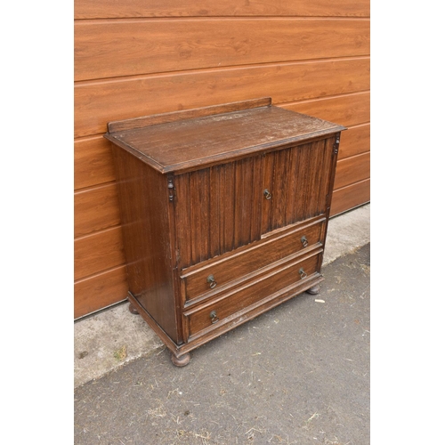 291 - 1930s oak Priory style cupboard over 2 draws raised on feet. 99 x 54 x 103.In good functional condit... 