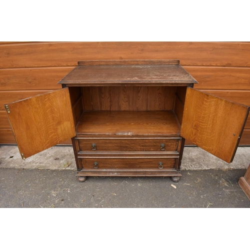 291 - 1930s oak Priory style cupboard over 2 draws raised on feet. 99 x 54 x 103.In good functional condit... 