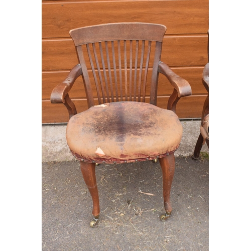 293 - A pair of Edwardian office or captains style chairs with upholstered seats on casters. The upholster... 