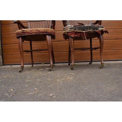 293 - A pair of Edwardian office or captains style chairs with upholstered seats on casters. The upholster... 