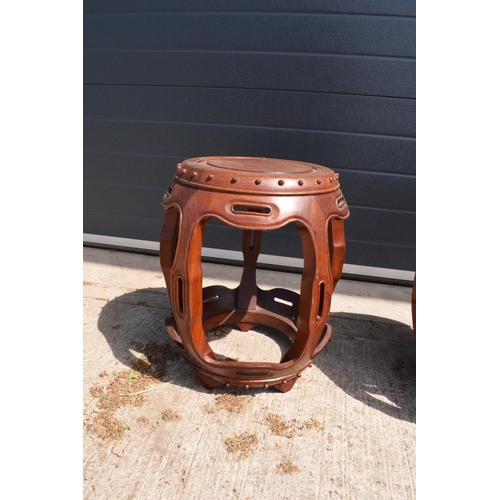 310 - A pair of 20th century Chinese style hardwood barrel/ drum stools. 46cm tall. 41cm at the widest poi... 