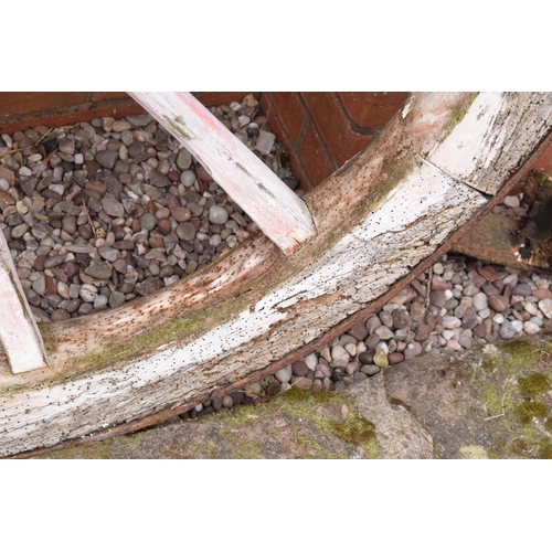 318 - A pair of early 20th century cart wheels with metal rims in a painted pink colour. 130cm diameter. T... 