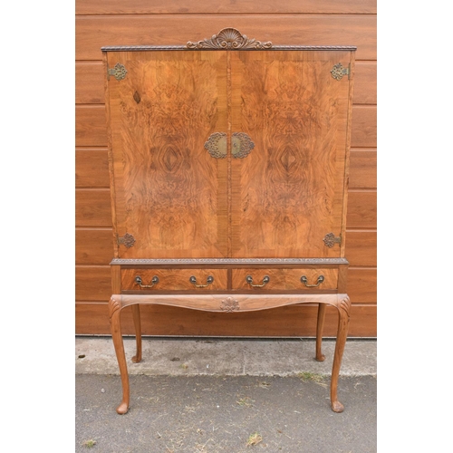 319 - An early 20th Century Queen Anne style walnut drinks / cocktail cabinet with the doors opening to re... 