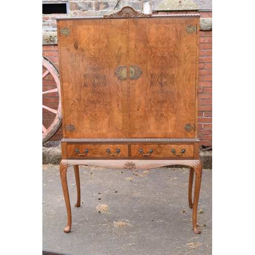 319 - An early 20th Century Queen Anne style walnut drinks / cocktail cabinet with the doors opening to re... 