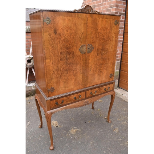 319 - An early 20th Century Queen Anne style walnut drinks / cocktail cabinet with the doors opening to re... 