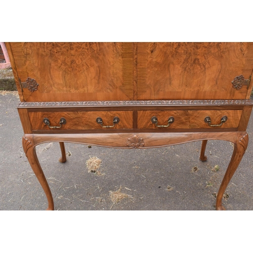 319 - An early 20th Century Queen Anne style walnut drinks / cocktail cabinet with the doors opening to re... 