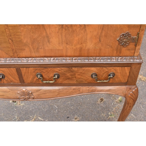 319 - An early 20th Century Queen Anne style walnut drinks / cocktail cabinet with the doors opening to re... 