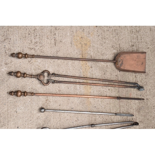 324 - A collection of fireside companion sets plus spare examples. 76cm tallest.