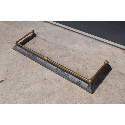 326 - An early 20th century cast metal fireside fender with brass rail. 121 x 37cm.