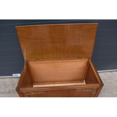 328 - A 1930s wooden blanket box with an ornate carved section. 96 x 50 x 57cm. In good functional conditi... 