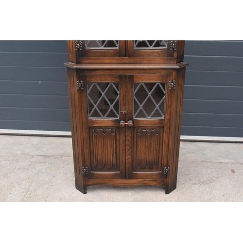 330 - A wooden 20th century Priory style corner display cabinet with glazed upper half. 172cm tall. In goo... 