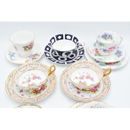 49 - A collection of china cups and saucers to include duos and trios by makers such as Royal Albert, Reg... 