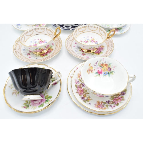 49 - A collection of china cups and saucers to include duos and trios by makers such as Royal Albert, Reg... 