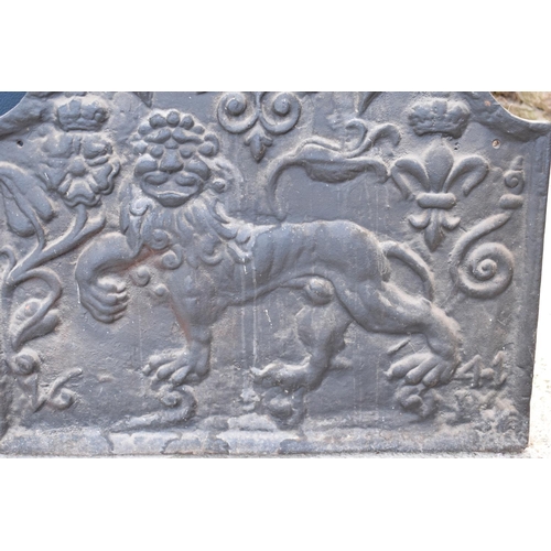 374 - An 18th century style cast iron fireback depicting a lion passant, a fleur de lys and a Scottish thi... 