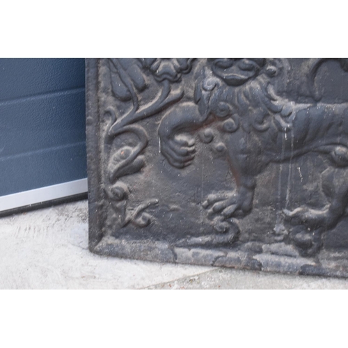 374 - An 18th century style cast iron fireback depicting a lion passant, a fleur de lys and a Scottish thi... 