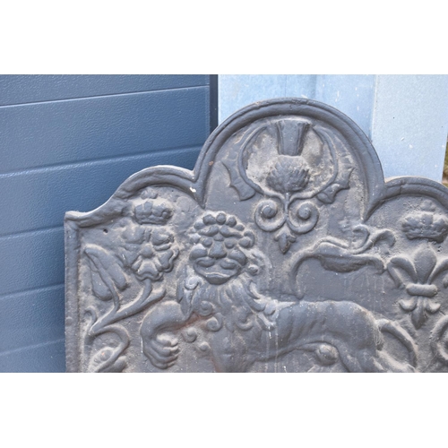 374 - An 18th century style cast iron fireback depicting a lion passant, a fleur de lys and a Scottish thi... 