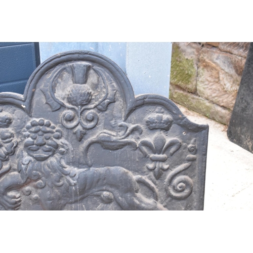 374 - An 18th century style cast iron fireback depicting a lion passant, a fleur de lys and a Scottish thi... 