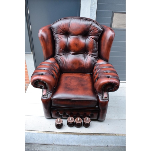 388 - A modern Chesterfield style wingback armchair with button back design raised on 4 wooden feet in oxb... 