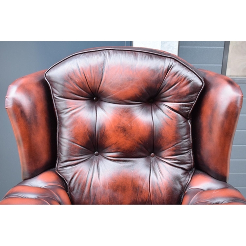 388 - A modern Chesterfield style wingback armchair with button back design raised on 4 wooden feet in oxb... 