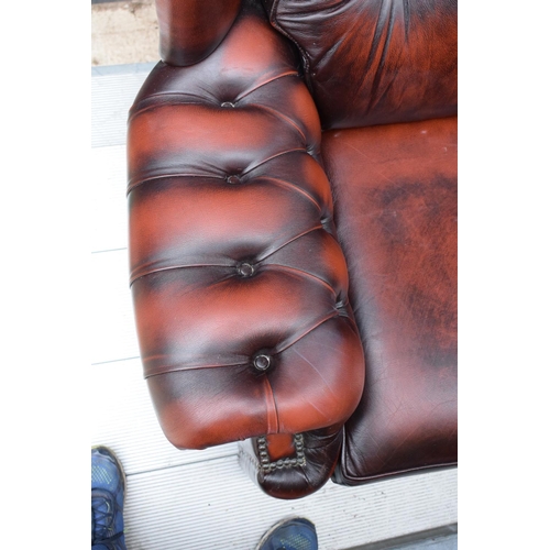 388 - A modern Chesterfield style wingback armchair with button back design raised on 4 wooden feet in oxb... 