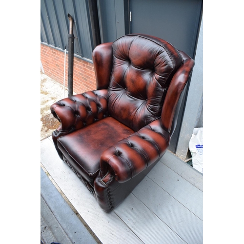 388 - A modern Chesterfield style wingback armchair with button back design raised on 4 wooden feet in oxb... 