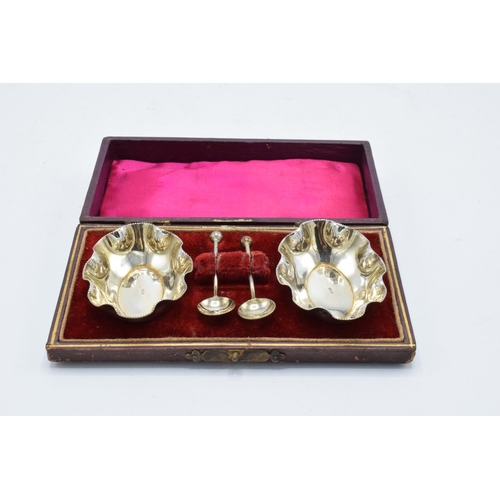 215F - A silver plated cased set of table salts and spoons.