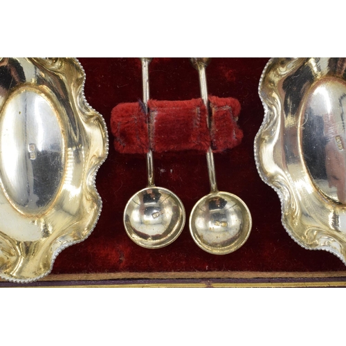 215F - A silver plated cased set of table salts and spoons.