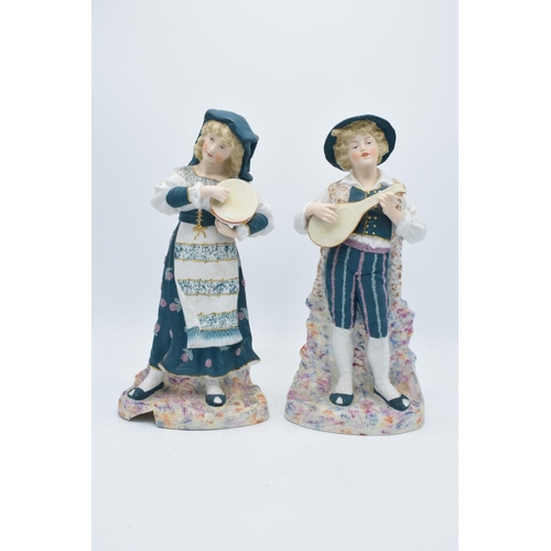 95B - A pair of early 20th century Continental bisque figures depicting a boy and a girl playing instrumen... 