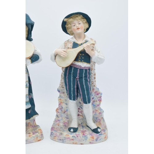 95B - A pair of early 20th century Continental bisque figures depicting a boy and a girl playing instrumen... 