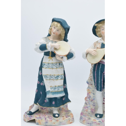 95B - A pair of early 20th century Continental bisque figures depicting a boy and a girl playing instrumen... 