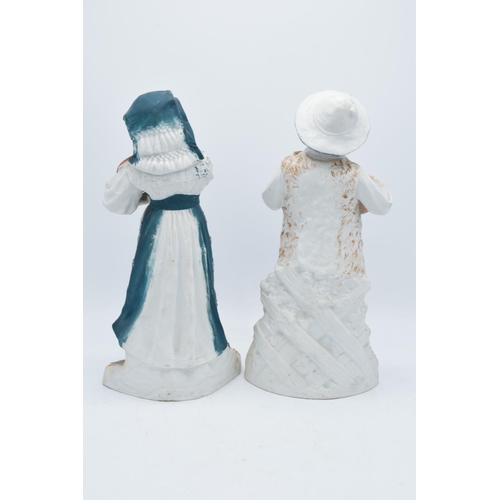 95B - A pair of early 20th century Continental bisque figures depicting a boy and a girl playing instrumen... 