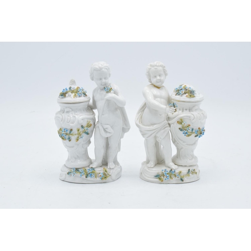 95D - A pair of Meissen Continental figures depicting cherubs with floral urns with 'JR' monogram to base ... 