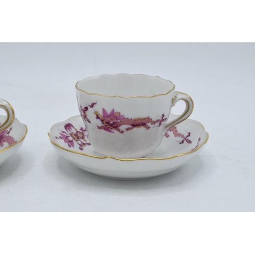 95H - A pair of early 20th century Meissen demitasse cups and saucers decorated with a purple dragon desig... 