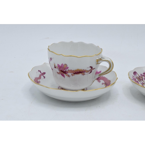 95H - A pair of early 20th century Meissen demitasse cups and saucers decorated with a purple dragon desig... 