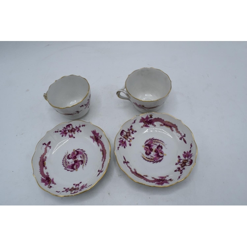 95H - A pair of early 20th century Meissen demitasse cups and saucers decorated with a purple dragon desig... 